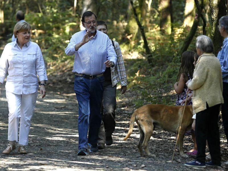 Rajoy y Merkel caminando juntos hacia Santiago